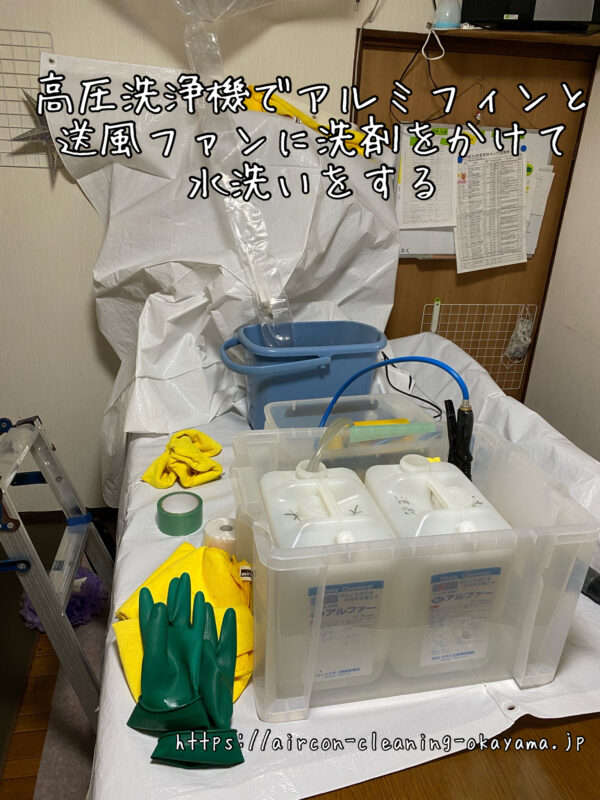 高圧洗浄機でアルミフィンと送風ファンに洗剤をかけて水洗いをする