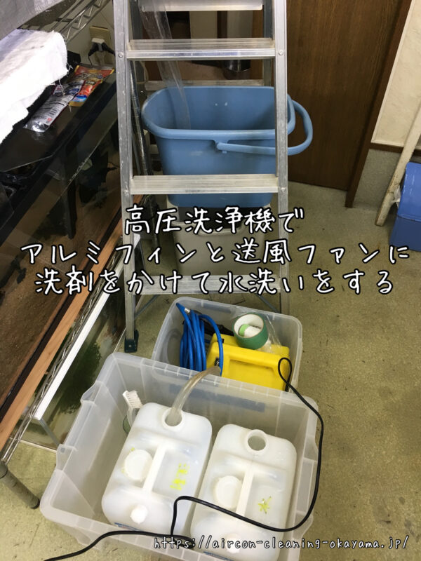 高圧洗浄機でアルミフィンと送風ファンに洗剤をかけて水洗いをする