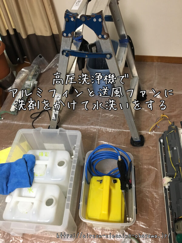 高圧洗浄機でアルミフィンと送風ファンに洗剤をかけて水洗いをする