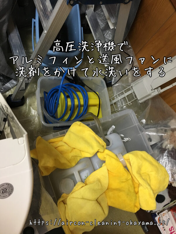 高圧洗浄機でアルミフィンと送風ファンに洗剤をかけて水洗いをする