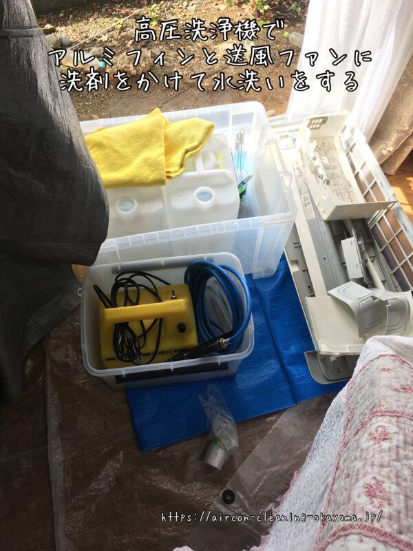 高圧洗浄機でアルミフィンと送風ファンに洗剤をかけて水洗いをする