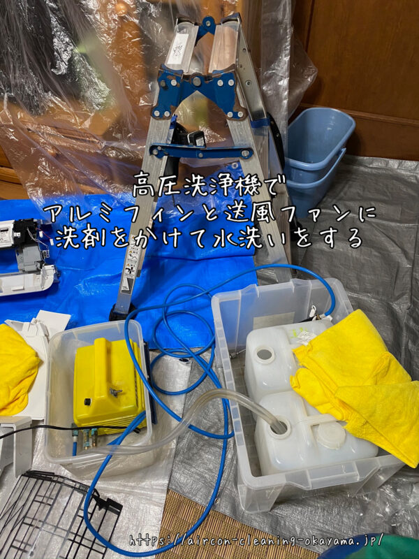 高圧洗浄機でアルミフィンと送風ファンに洗剤をかけて水洗いをする