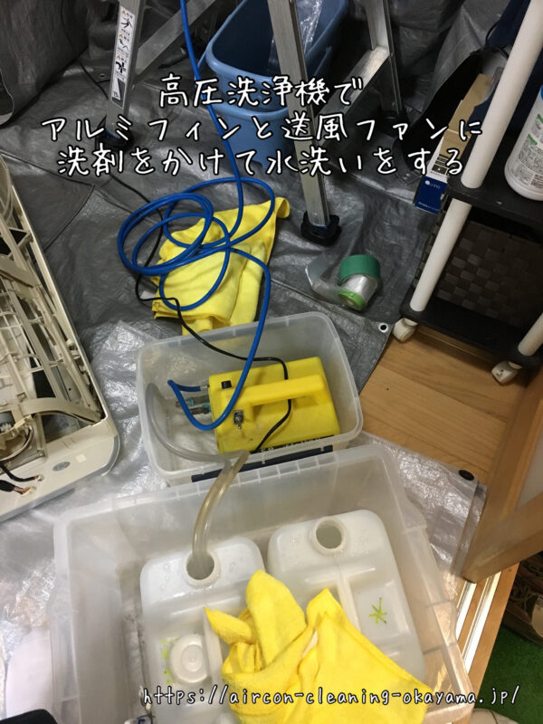 高圧洗浄機でアルミフィンと送風ファンに洗剤をかけて水洗いをする